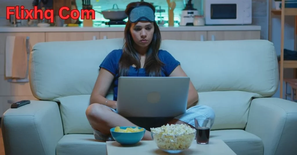 a person sitting on a couch with a laptop and popcorn flixhq com